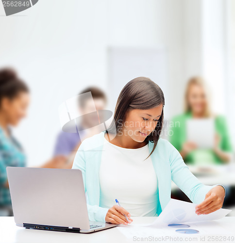 Image of asian businesswoman with laptop and documents