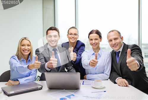 Image of business team showing thumbs up in office