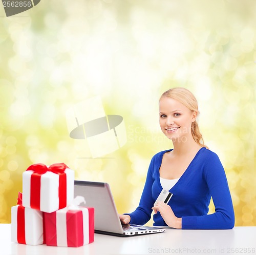 Image of woman with gifts, laptop computer and credit card