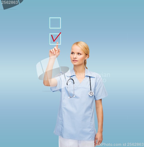 Image of doctor or nurse drawing checkmark into checkbox