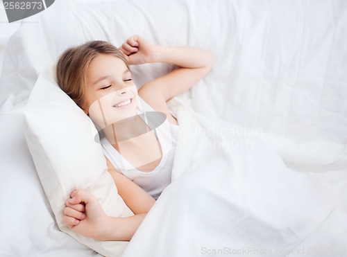 Image of smiling girl child waking up in bed at home