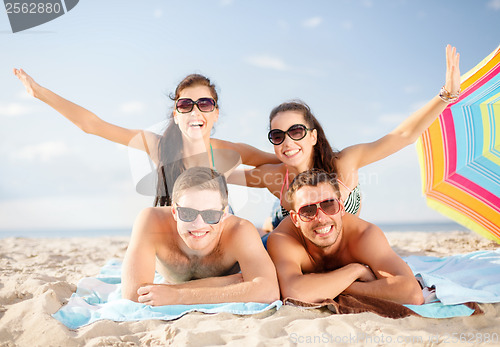 Image of group of smiling people having fun on the beach