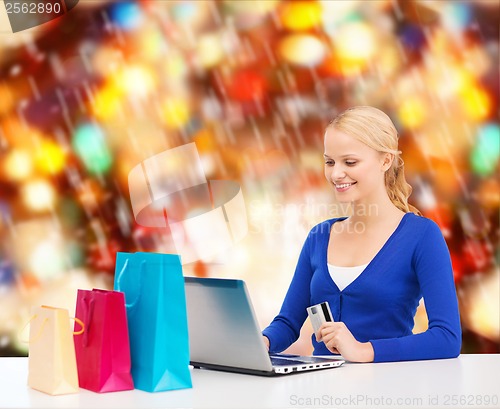 Image of woman with laptop, shopping bags and credit card