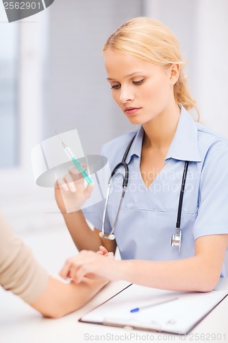 Image of calm female doctor or nurse with syringe