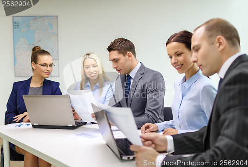 Image of business team with laptop having discussion