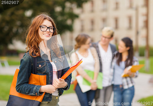 Image of female student in eyglasses with folders