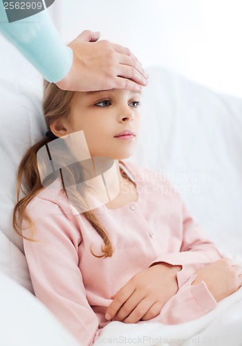 Image of ill girl child with thermometer and caring mother