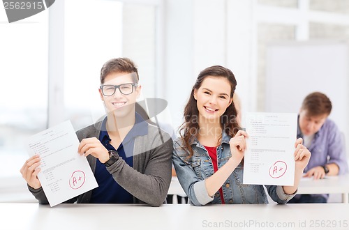 Image of two teenagers holding test or exam with grade A