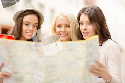 Image of beautiful girls looking into tourist map in city