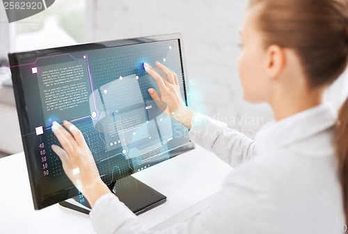 Image of smiling businesswoman with touchscreen in office