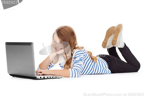 Image of smiling student girl with laptop computer lying