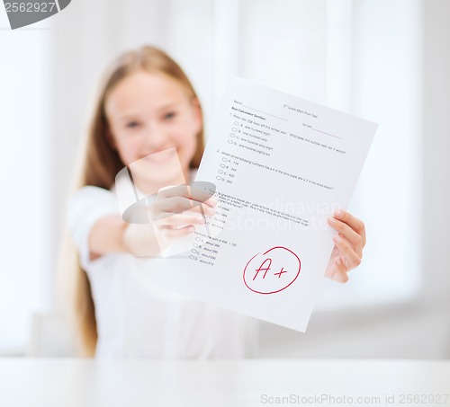 Image of smiling little student girl with test and A grade