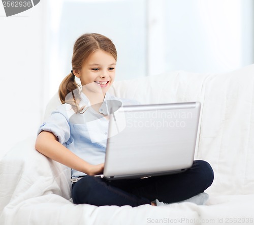 Image of smiling girl with laptop computer at home
