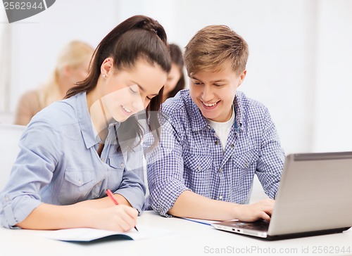 Image of students with laptop and notebooks at school