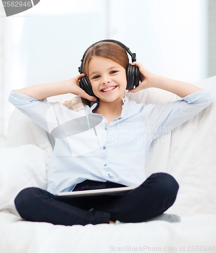 Image of girl with tablet pc and headphones at home