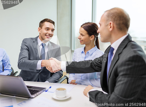 Image of two businessman shaking hands in office