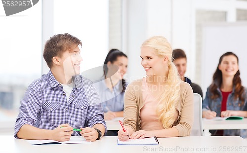 Image of two teenagers with notebooks at school