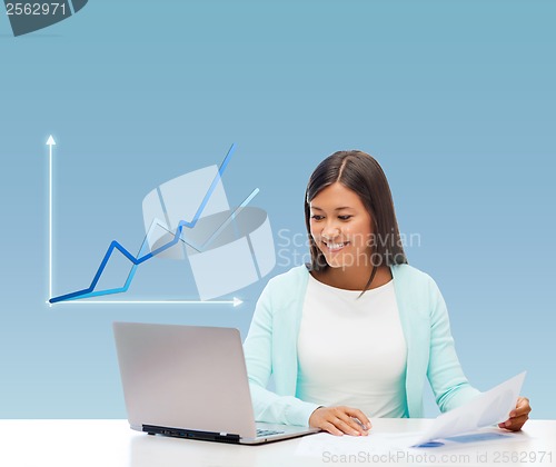 Image of asian businesswoman with laptop and documents