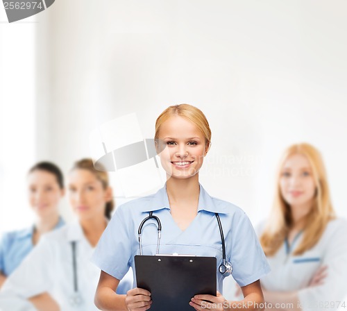 Image of smiling female doctor or nurse with clipboard