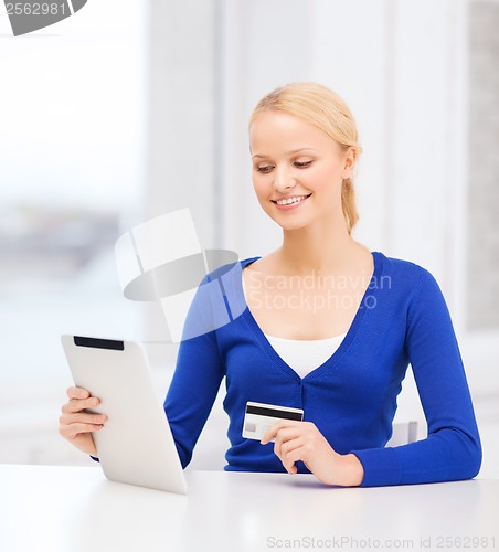 Image of smiling woman with tablet pc and credit card