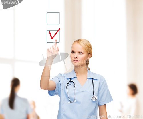 Image of smiling doctor or nurse pointing to checkmark