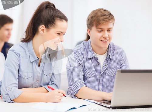 Image of students with laptop and notebooks at school