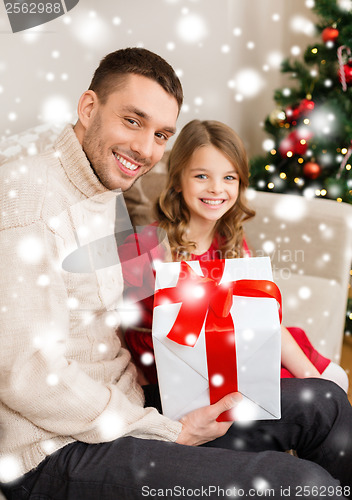 Image of smiling father and daughter holding gift box