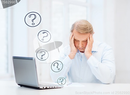 Image of stressed old man filling a form at home