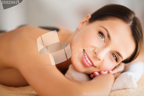 Image of beautiful woman in spa salon with hot stones