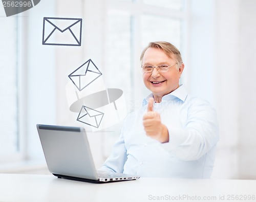 Image of old man with laptop computer showing thumbs up