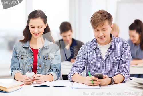Image of students looking into smartphone at school