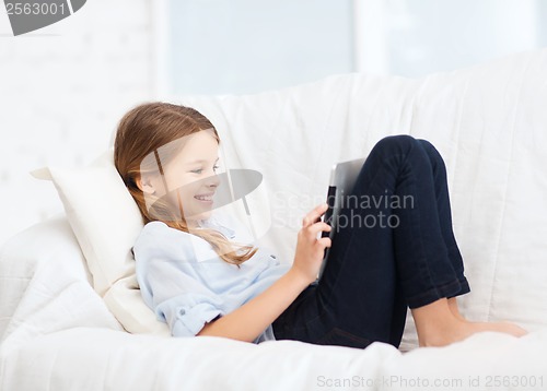 Image of smiling girl with tablet computer at home