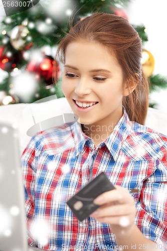 Image of smiling woman with laptop computer and credit card