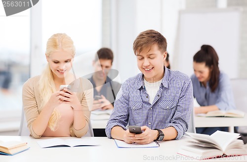 Image of students looking into smartphone at school
