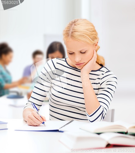 Image of concentrated woman studying in college