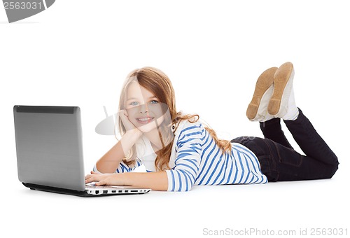 Image of smiling student girl with laptop computer lying
