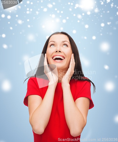 Image of amazed laughing young woman in red dress