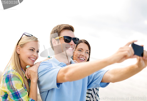 Image of group of friends taking picture with smartphone