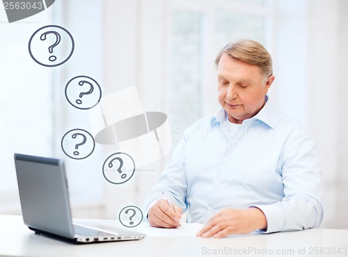 Image of old man filling a form at home