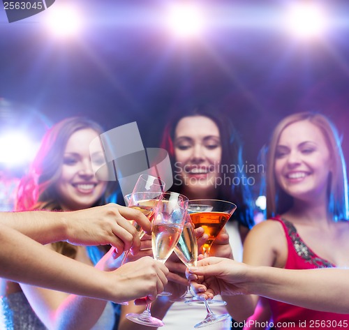 Image of three smiling women with cocktails and disco ball