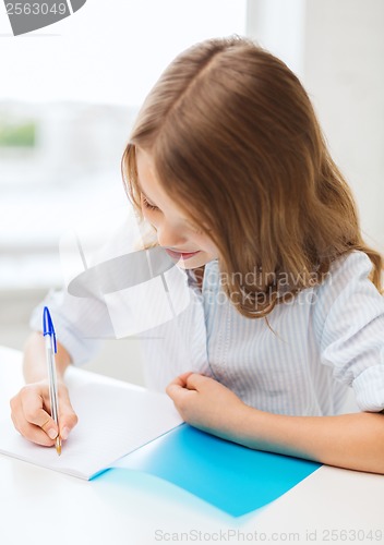 Image of student girl writing in notebook at school