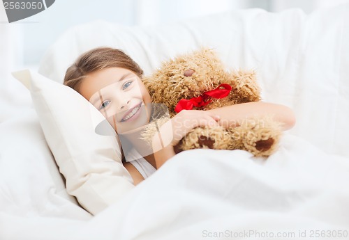 Image of little girl with teddy bear sleeping at home