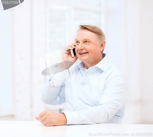 Image of old man at home with smartphone