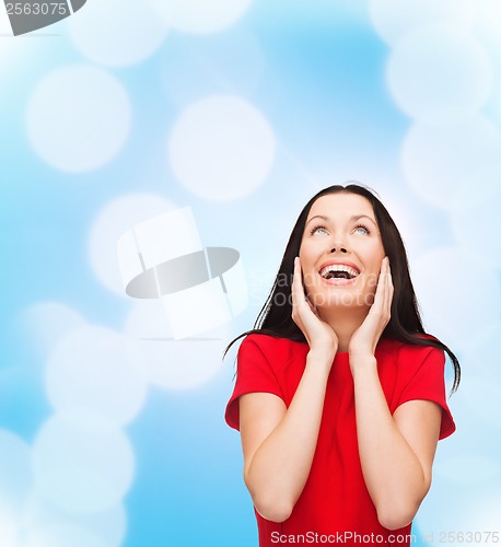 Image of amazed laughing young woman in red dress