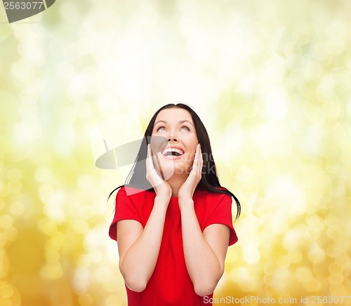 Image of amazed laughing young woman in red dress