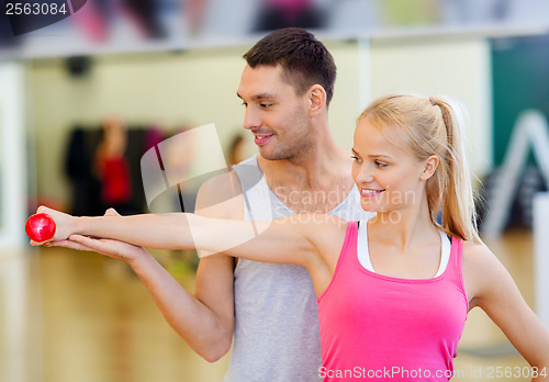 Image of male trainer with woman working out with dumbbell