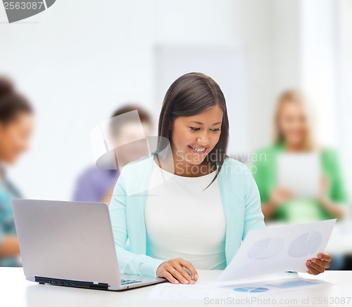 Image of asian businesswoman with laptop and documents
