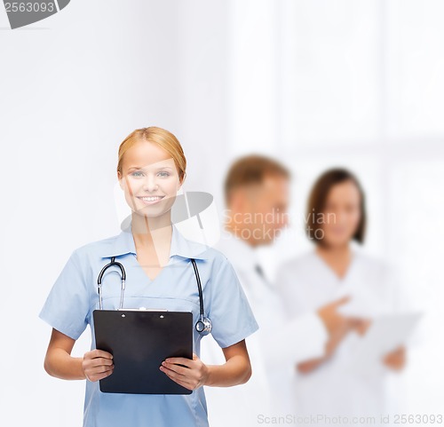 Image of smiling female doctor or nurse with clipboard