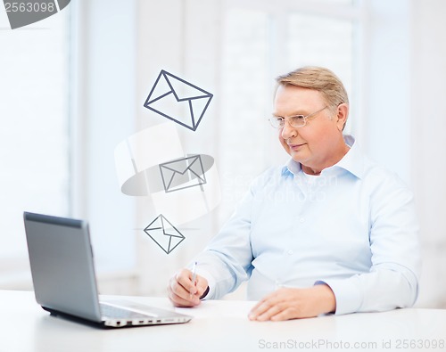 Image of old man in eyeglasses filling a form at home