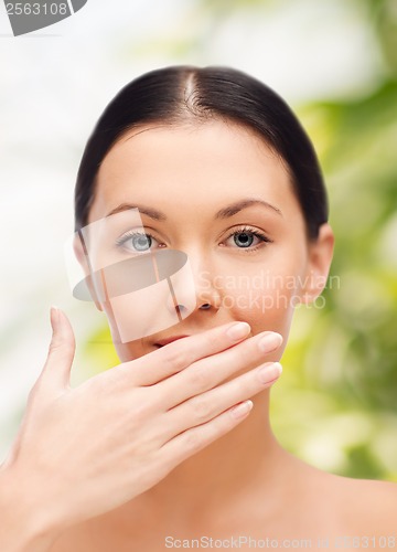 Image of beautiful woman covering her mouth